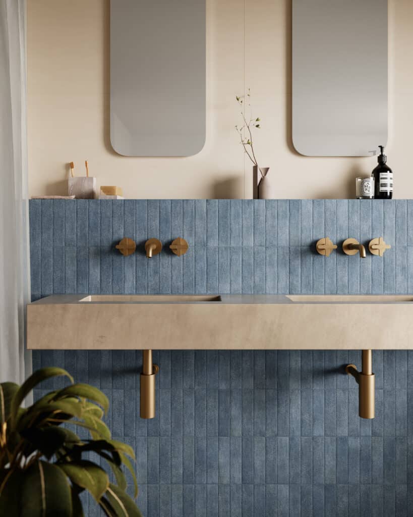 Luxe badkamer met blauwe tegels en een dubbele wastafel.